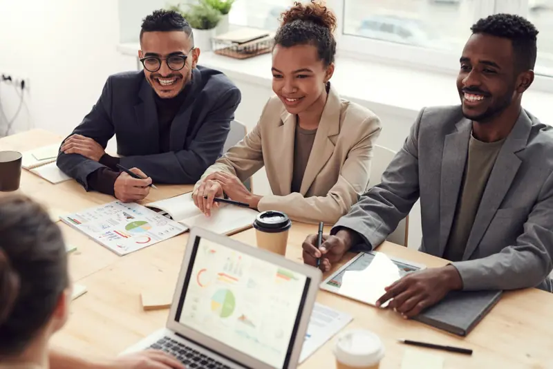 Equipe reunida sorrindo em uma reunião de trabalho