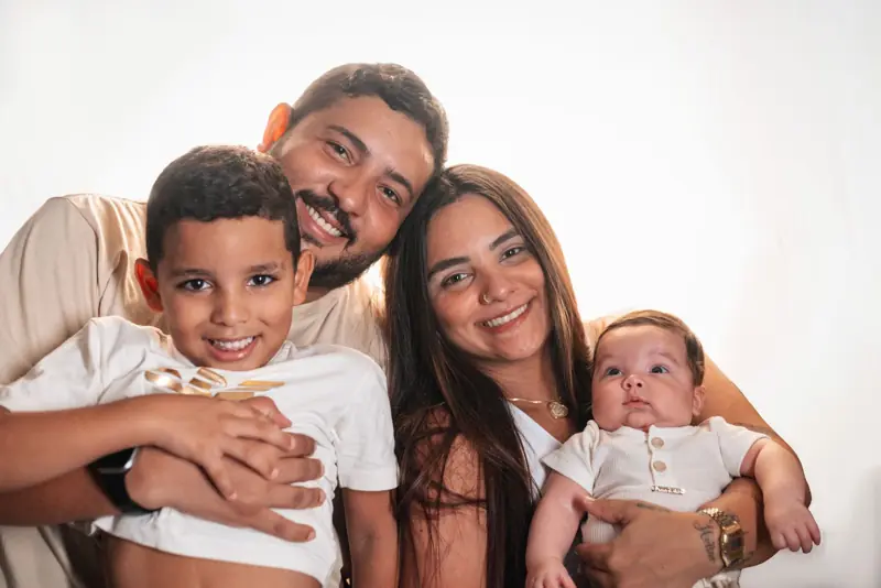 Família sorrindo junta em casa, pai, mãe e dois filhos