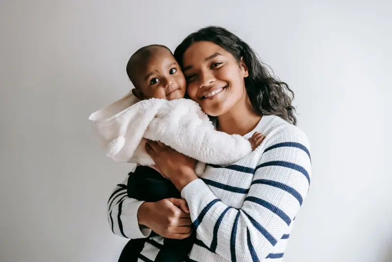 Mãe sorrindo com o bebê no colo